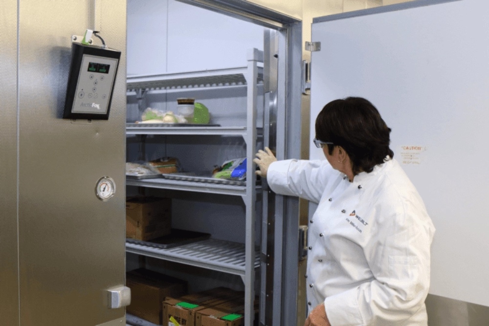 Repair vs Replace: The Ultimate Guide to Maximizing Walk-In Freezer Efficiency插图2 a person is inspecting a walk-in freezer