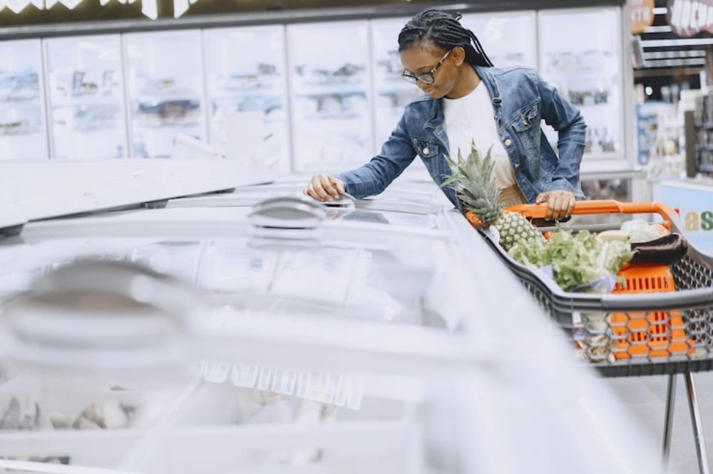 R290 vs HFCs: Why Supermarkets Must Transition to Natural Refrigerants插图 woman shopping in supermarket opening freezer